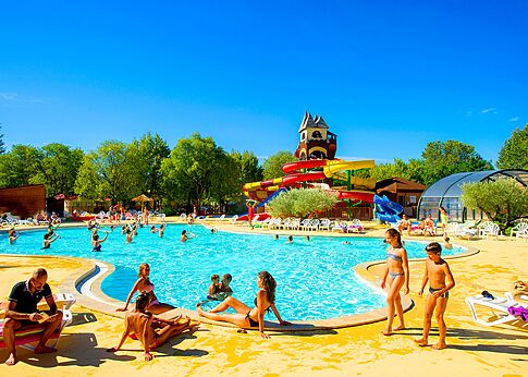Piscina exterior con toboganes y sillas en el camping CAPFUN Bastide en Nîmes (30).