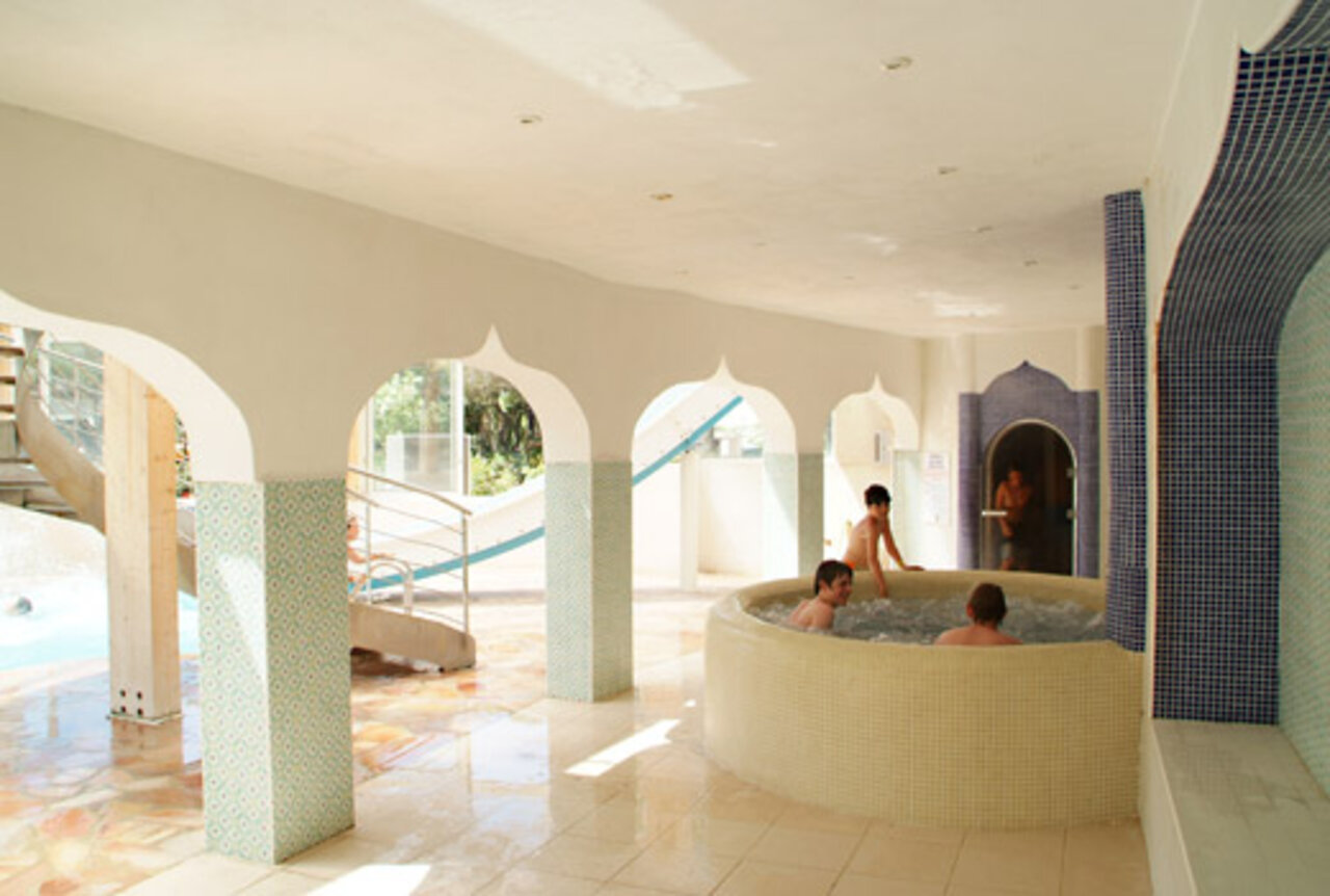 Jacuzzi y tobog�n acu�tico interior en el camping CAPFUN La Baume - La Palmeraie.