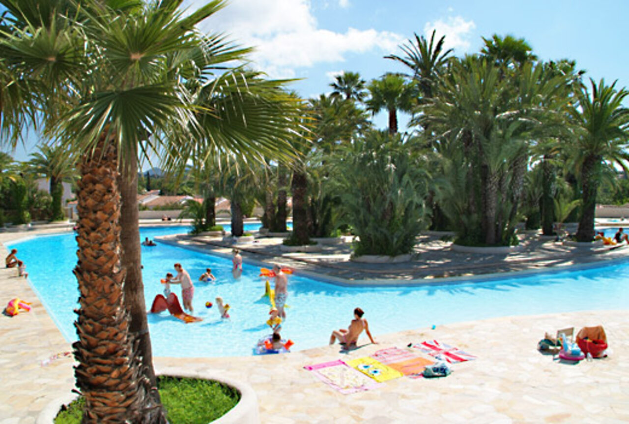 Gran piscina exterior con palmeras y juegos acu�ticos en el camping CAPFUN La Baume - La Palmeraie en Fr�jus (83).