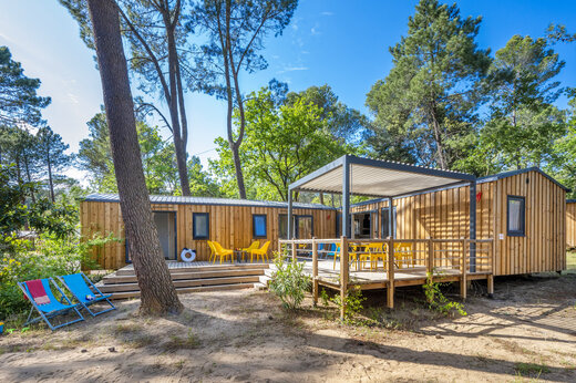Casa m�vil de madera con terraza y sillas en el camping CAPFUN Beauregard en MORNAS (84).