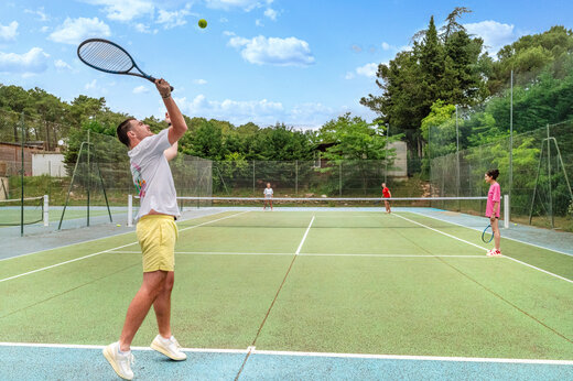 Cancha de tenis con jugadores en el camping CAPFUN Beauregard en MORNAS (84).