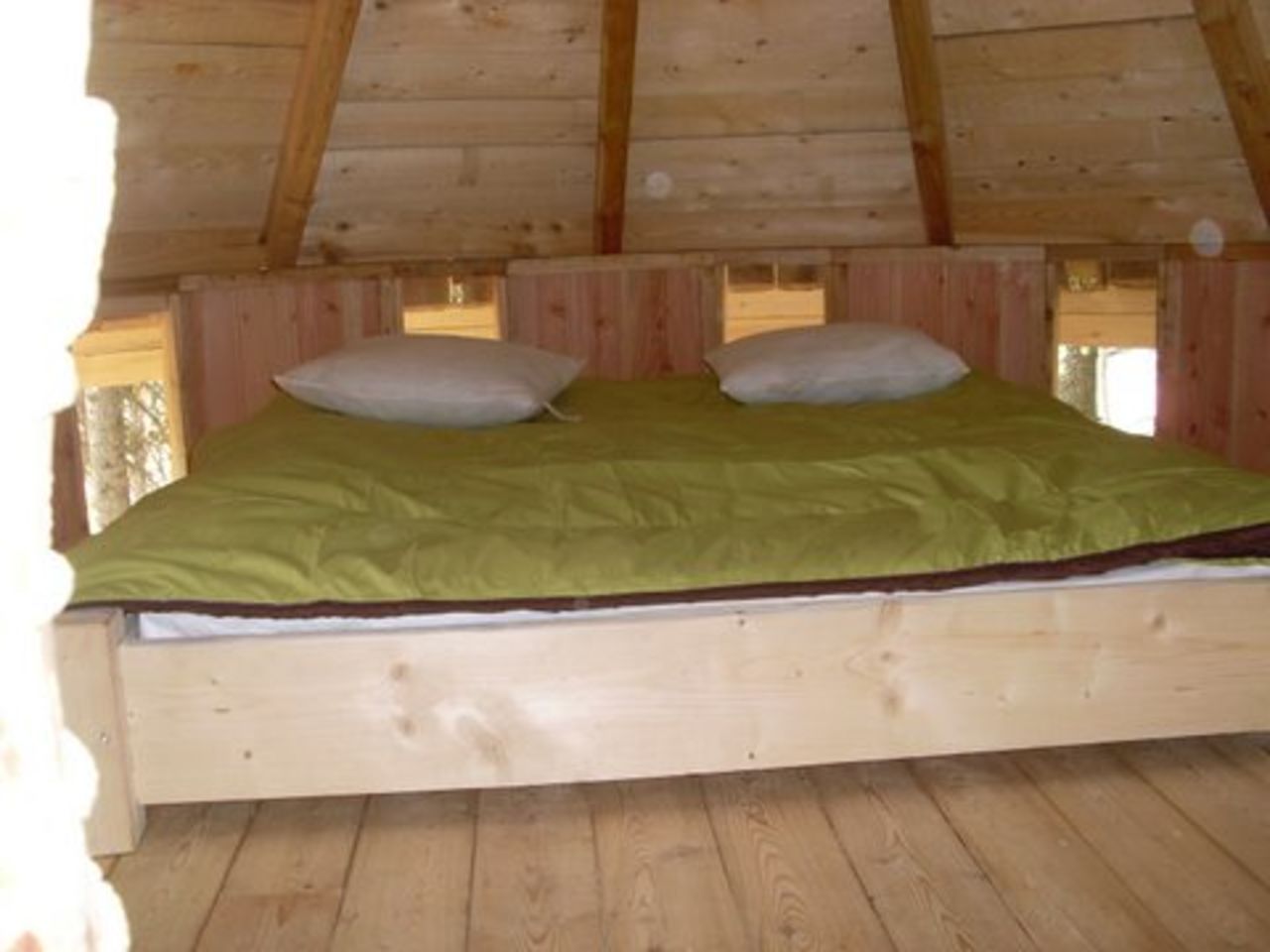 Cama doble de madera, edred�n verde, caba�a en CAPFUN Beauregard, Mornas (84).