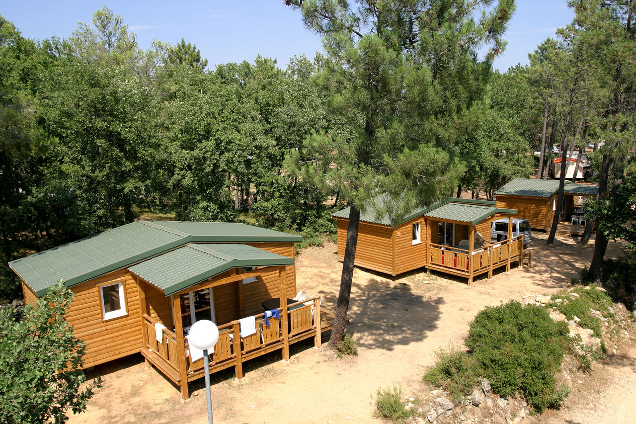 Caba�as de madera con terrazas sombreadas en el camping CAPFUN Beauregard en Mornas (84).