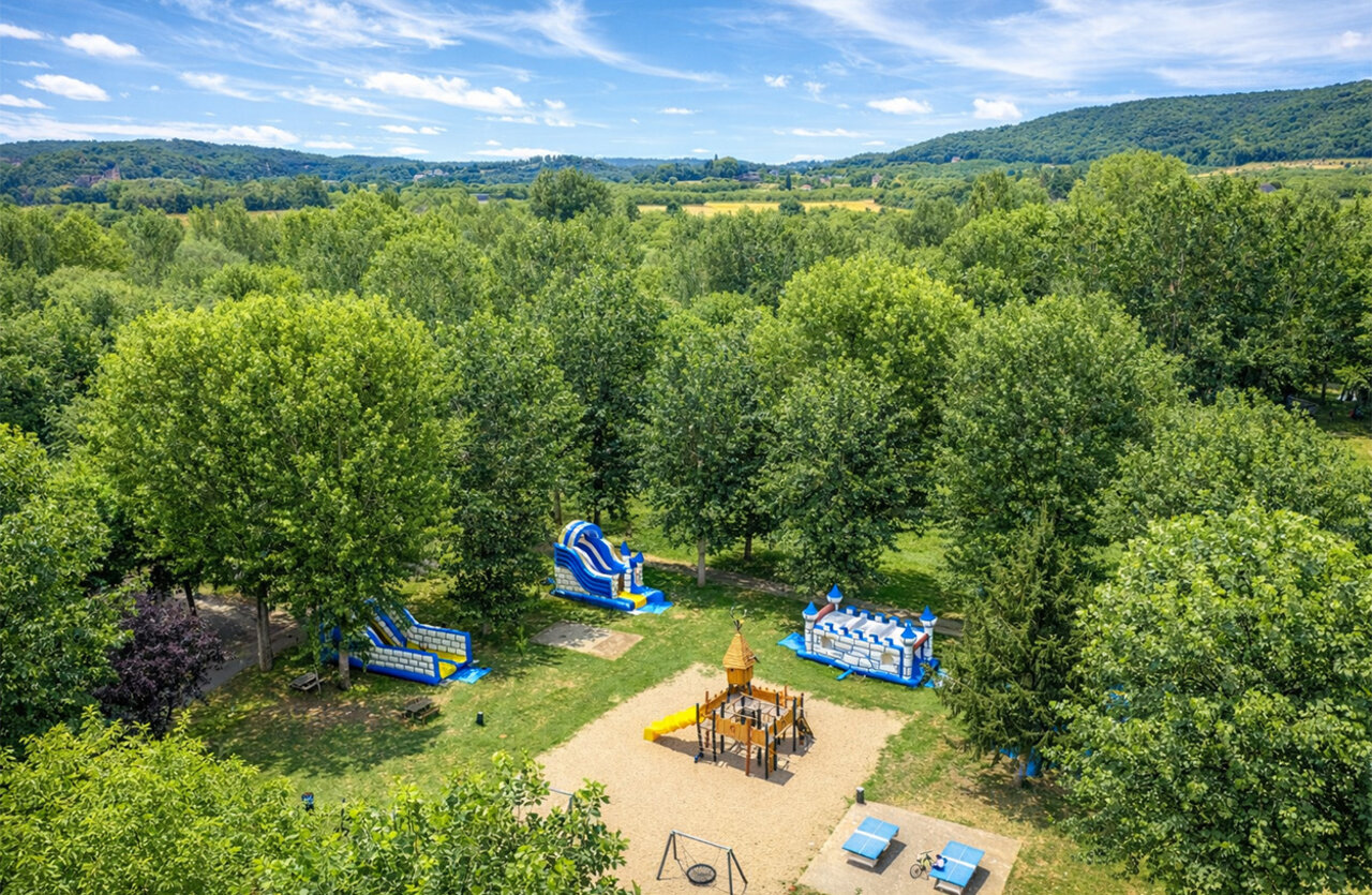 Zona de juegos con hinchables, toboganes y columpios en el camping CLICOCHIC Beau Rivage en LA ROQUE-GAGEAC (24).