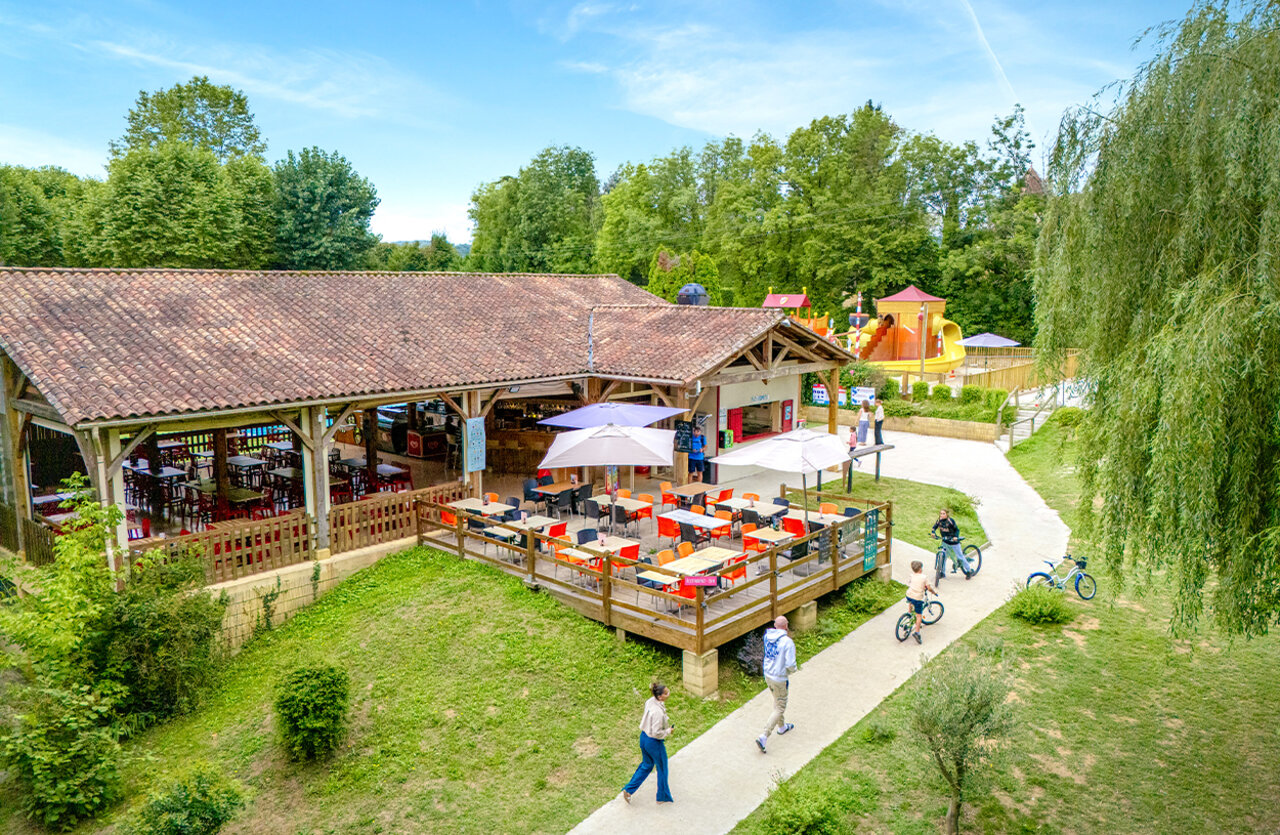 Restaurante-bar con terraza y zona de juegos en el camping CLICOCHIC Beau Rivage en LA ROQUE-GAGEAC (24).