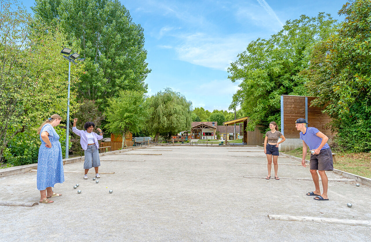 Campo de petanca animado con veraneantes jugando en el camping CLICOCHIC Beau Rivage.