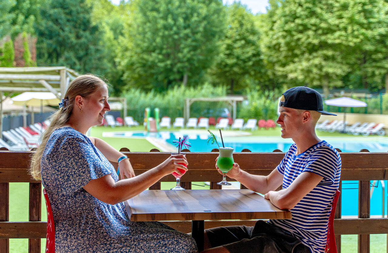 Pareja disfrutando c�cteles en el bar, piscina, en el camping CLICOCHIC Beau Rivage en LA ROQUE-GAGEAC (24).