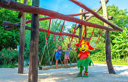Dos niños y una mascota en un puente de cuerda en el área de juegos del camping CLICOCHIC Beau Rivage en LA ROQUE-GAGEAC (24).