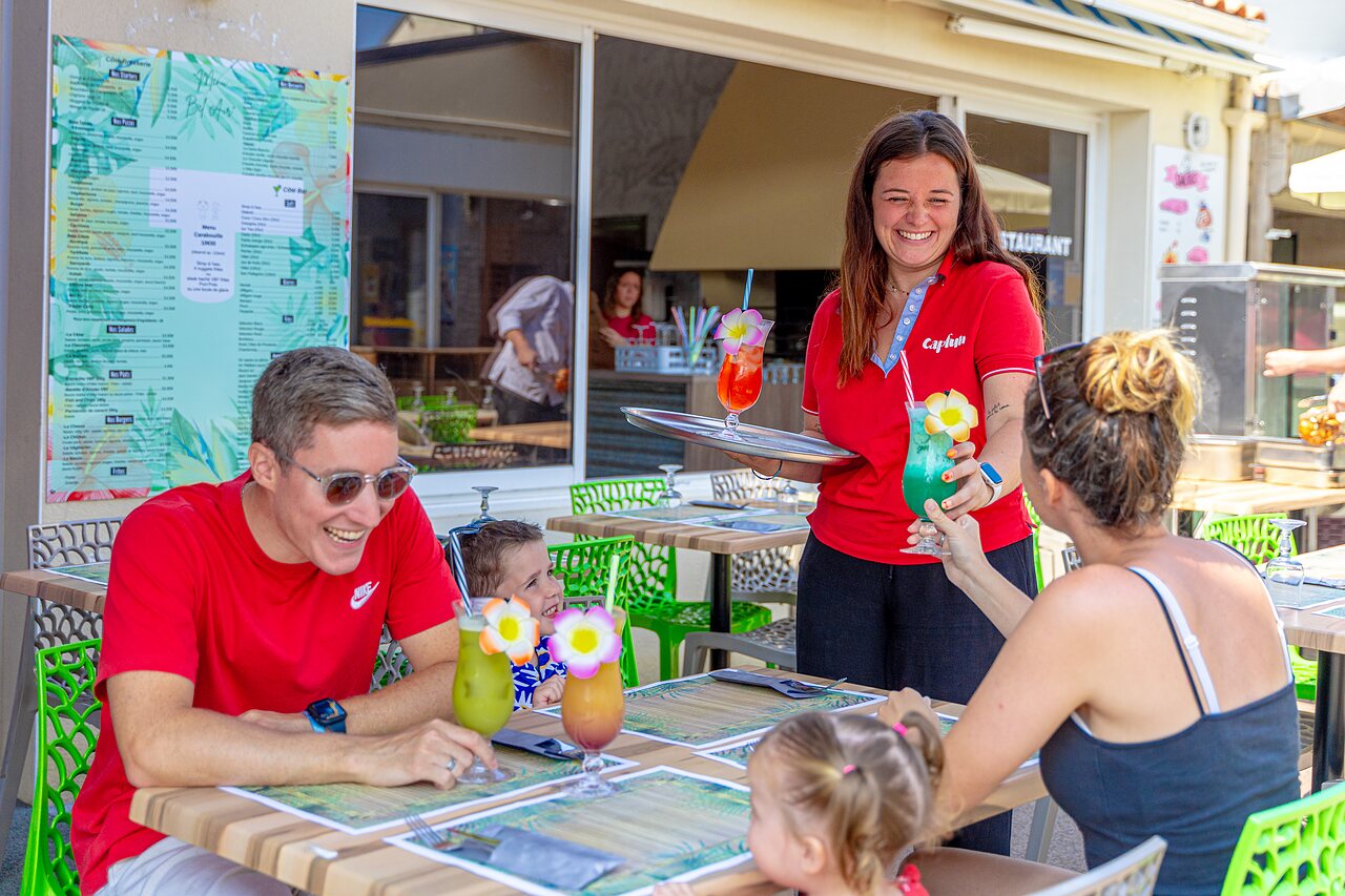 Familia disfrutando c�cteles coloridos en terraza restaurante en camping CAPFUN Bel Air en Aiguillon sur Mer (85).
