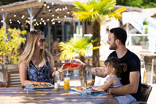 Familia almorzando en la terraza del restaurante del camping CLICOCHIC Bimbo en BISCARROSSE (40).
