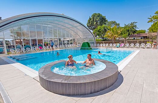 Piscina cubierta, jacuzzi y tobogán en el camping VAGUES OCEANES Blancs Chênes.
