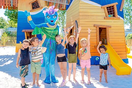 Mascota y niños en la zona de juegos del camping VAGUES OCEANES Blancs Chênes.