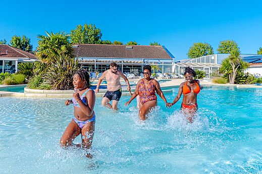 Piscina exterior, familia divirtiéndose en el camping VAGUES OCEANES Blancs Chênes en LA TRANCHE SUR MER (85).