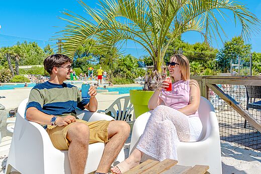 Piscina exterior, pareja con bebidas, camping VAGUES OCEANES, LA TRANCHE SUR MER.
