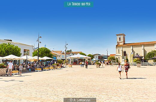 Plaza animada de La Tranche-sur-Mer con terrazas y carrusel, Vandea.