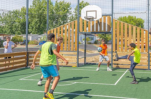 Cancha multideporte, jóvenes jugando al fútbol, camping VAGUES OCEANES Blancs Chênes.