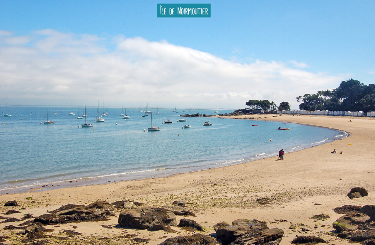 Playa de la Isla de Noirmoutier con barcos y caba�as de playa.