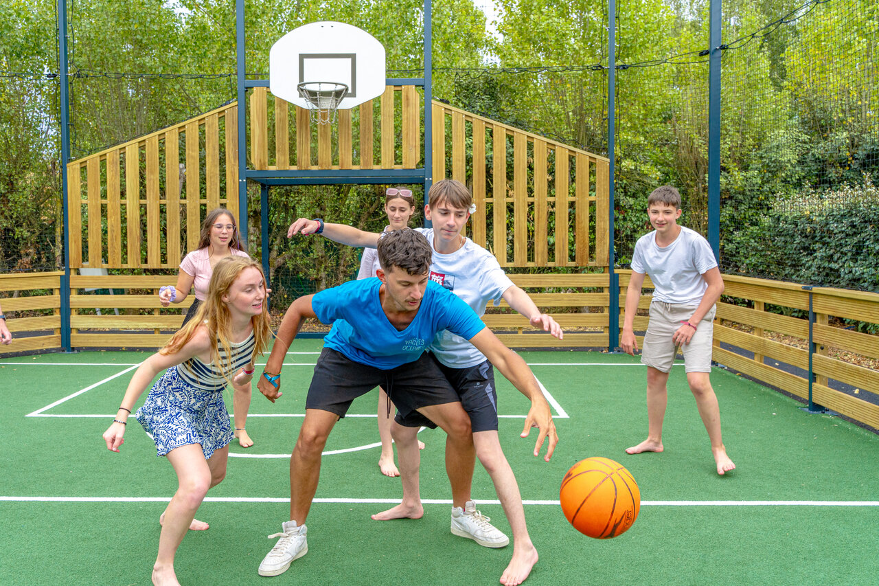 Baloncesto en cancha multideporte con j�venes en el camping VAGUES OCEANES Bois Joly.