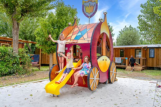 Parque infantil temático con tobogán y niños en el camping VAGUES OCEANES Bois Joly.