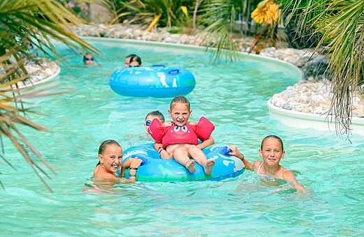 Niños en piscina con flotadores en el camping VAGUES OCEANES Bois Joly en Saint-Jean-de-Monts (85).