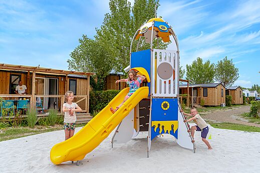 Zona de juegos infantil con tobogán y estructura en el camping VAGUES OCEANES Bois Joly en Saint-Jean-de-Monts (85).