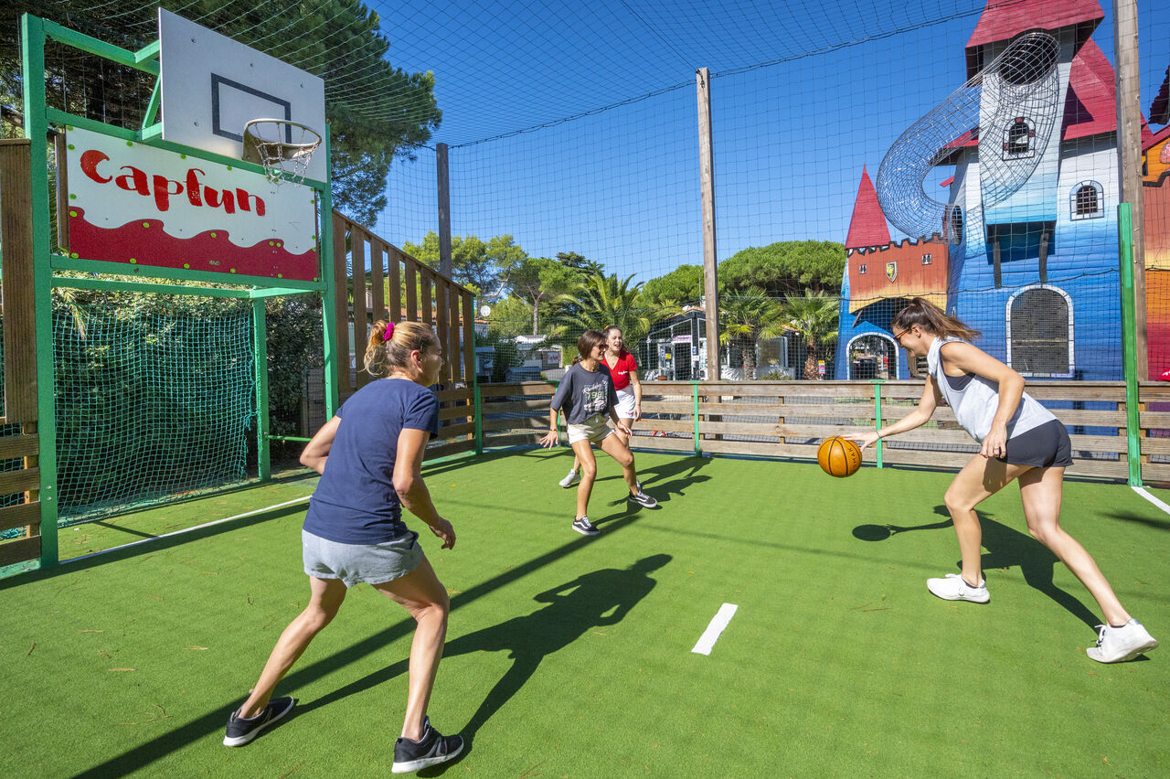 Cancha multideporte con jugadores de baloncesto en el camping CAPFUN Bonne Etoile en BOIS PLAGE EN RE (17).