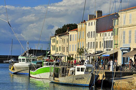 Puerto pesquero animado con barcos y fachadas coloridas en La Rochelle.