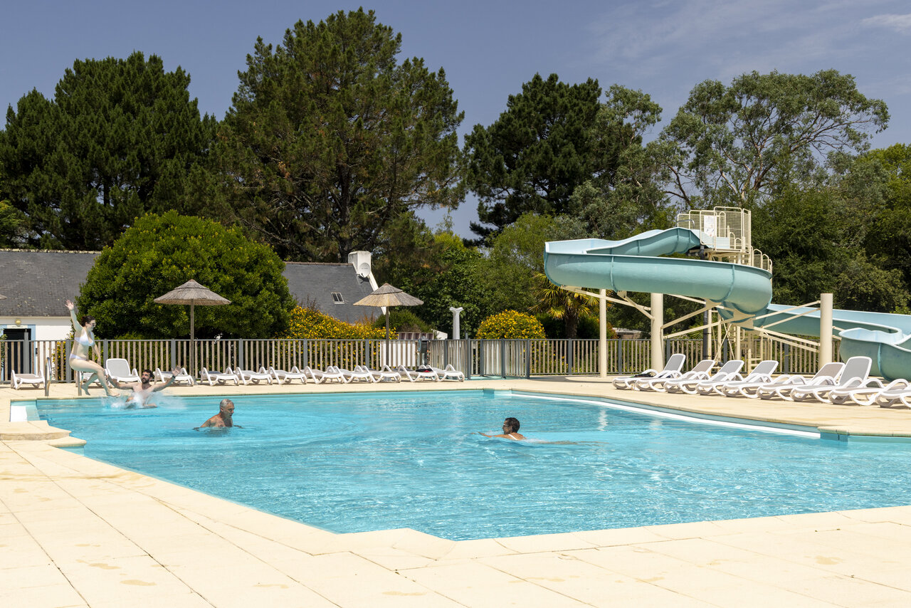 Piscina exterior con tobog�n acu�tico y ba�istas en el camping CLICOCHIC Bord�n�o Belle-�le-en-Mer en Le Palais (56).
