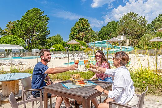 Familia brindando en el bar, piscina y tobog�n en camping CLICOCHIC Bord�n�o Belle-�le.