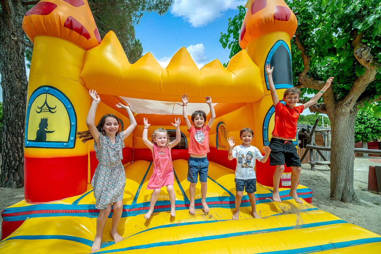 Castillo hinchable y ni�os felices en el camping CAPFUN Boucanet en LE GRAU DU ROI (30).