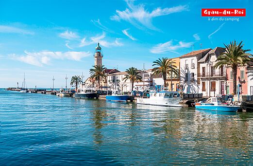 Puerto de Grau-du-Roi con faro, barcos y casas coloridas, Occitania.