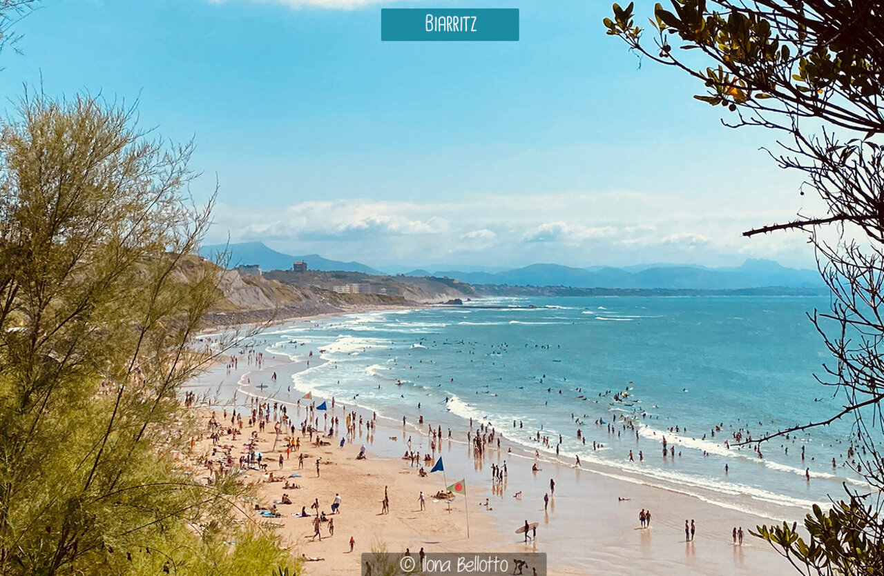Playa concurrida de Biarritz, Pa�s Vasco, con ba�istas y surfistas bajo el sol.