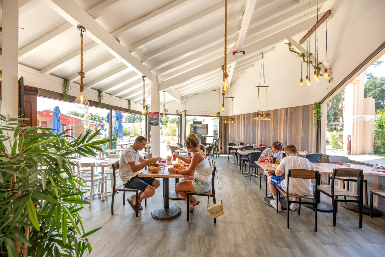 Restaurante interior moderno, clientes almorzando en camping VAGUES OCEANES Boudigau, LABENNE.