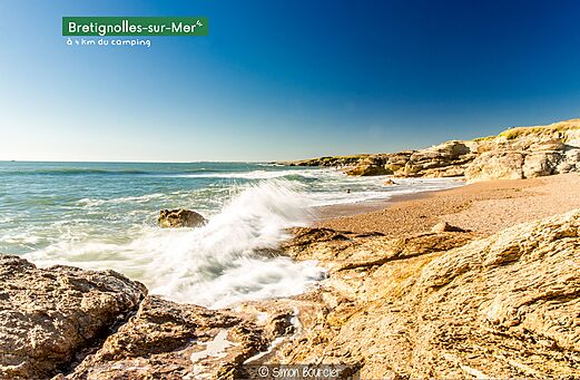 Playa rocosa de Brétignolles-sur-Mer con olas y acantilados, Vendée.
