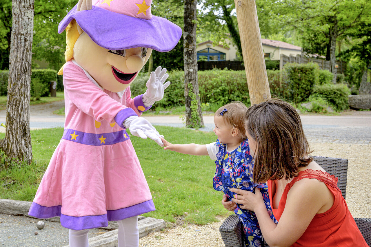 Mascota animando a un ni�o sonriente, actividad l�dica en el camping CAPFUN Breteche en Les Epesses (85).