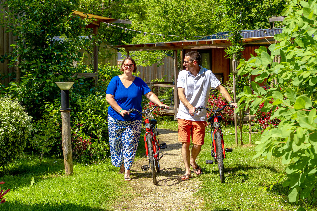 Pareja con bicicletas rojas, sendero verde, camping CAPFUN Breteche en Les Epesses (85).