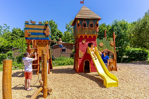 Zona de juegos castillo con tobogán y niños en el camping CAPFUN Breteche en Les Epesses (85).