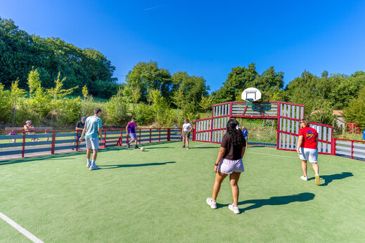 Campo multideporte con veraneantes jugando al fútbol en el camping CAPFUN Breteche en Les Epesses (85).