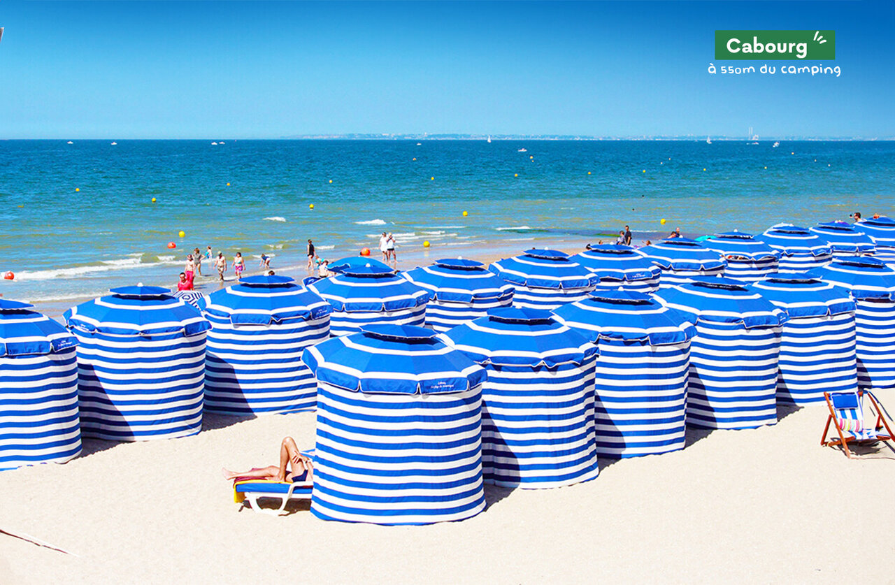 Playa de Cabourg con tiendas de playa a rayas, un lugar para visitar en Normand�a.