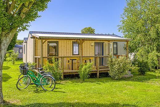 Mobil-home de madera con terraza y bicicletas en camping CLICOCHIC Brise de Cabourg (14).