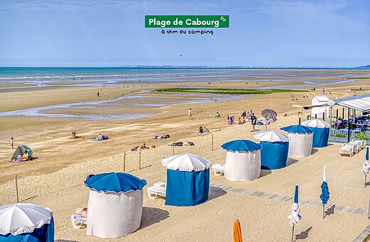 Playa de Cabourg con cabinas de playa y restaurante, lugar para visitar en Normandía.