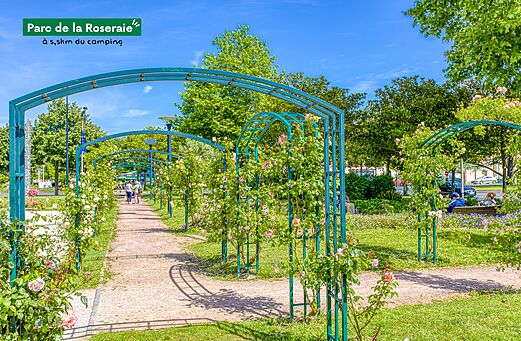 Sendero florido con arcos de rosas en el Parque de la Rosaleda, próximo al camping.