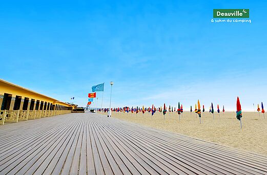 Paseo marítimo de Deauville, playa con sombrillas coloridas y cabinas, Normandía.