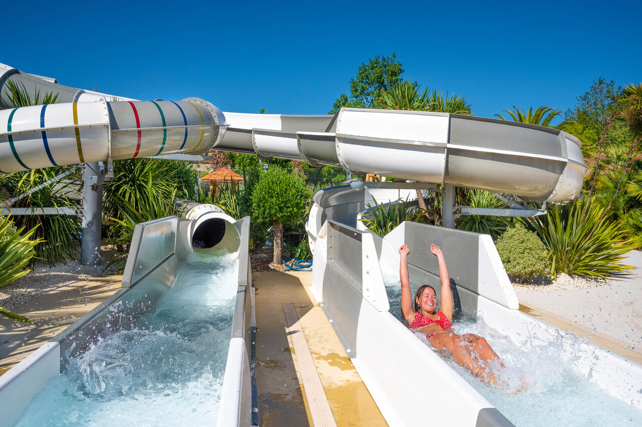 Mujer sonriente en tobog�n acu�tico en camping CLICOCHIC Cabanes d Ol�ron en ST GEORGES D'OLERON.