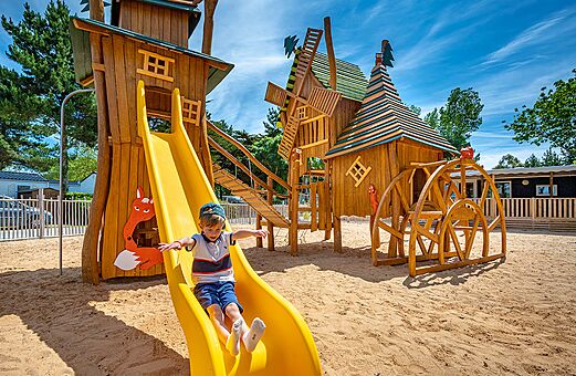 Niño en tobogán, parque infantil de madera en el camping CLICOCHIC Cabanes d Oléron en ST GEORGES D'OLERON (17).