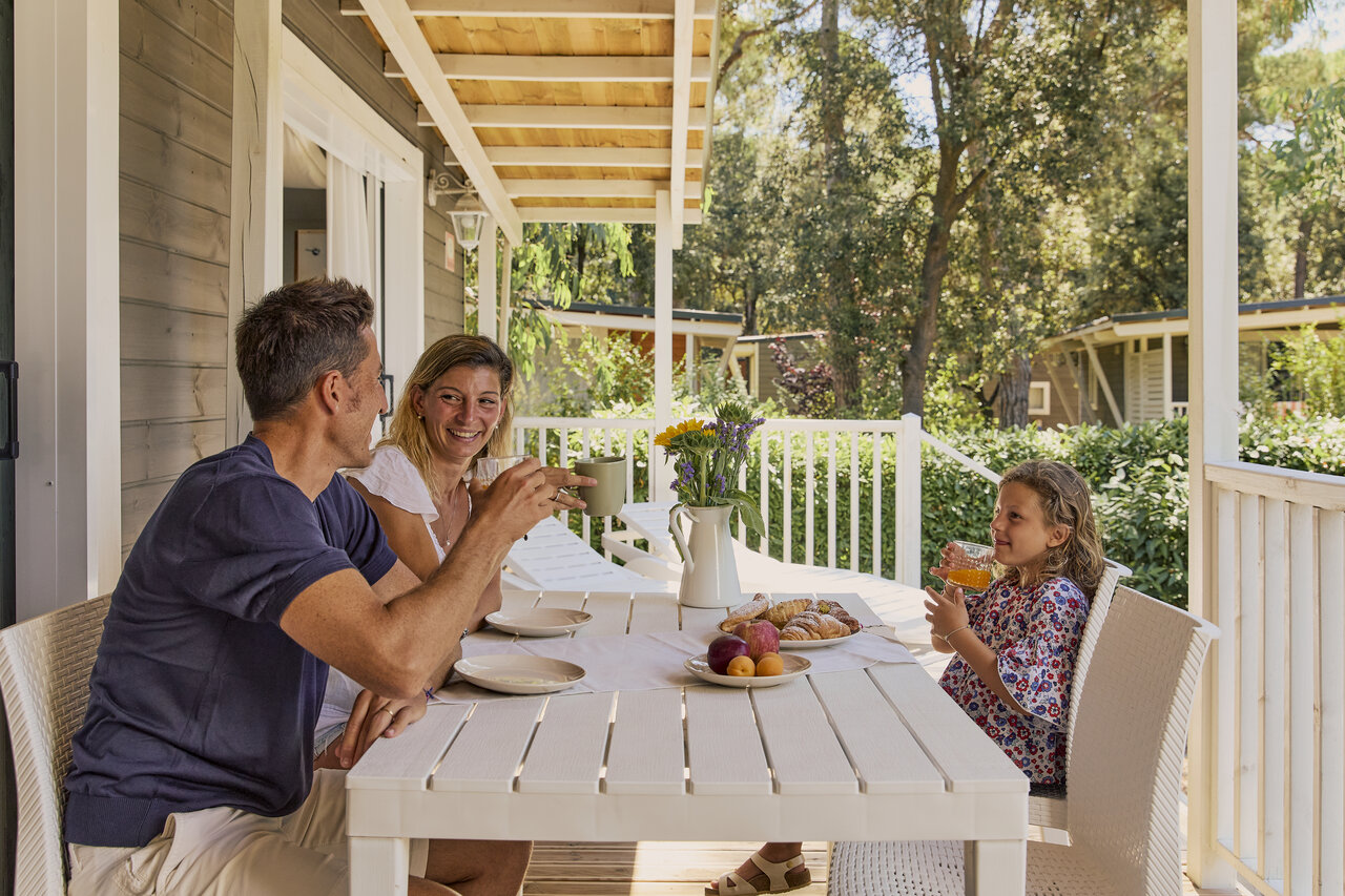 Familia desayunando terraza mobil-home en CAPFUN Campo dei Fiori en Rosignano Marittimo.