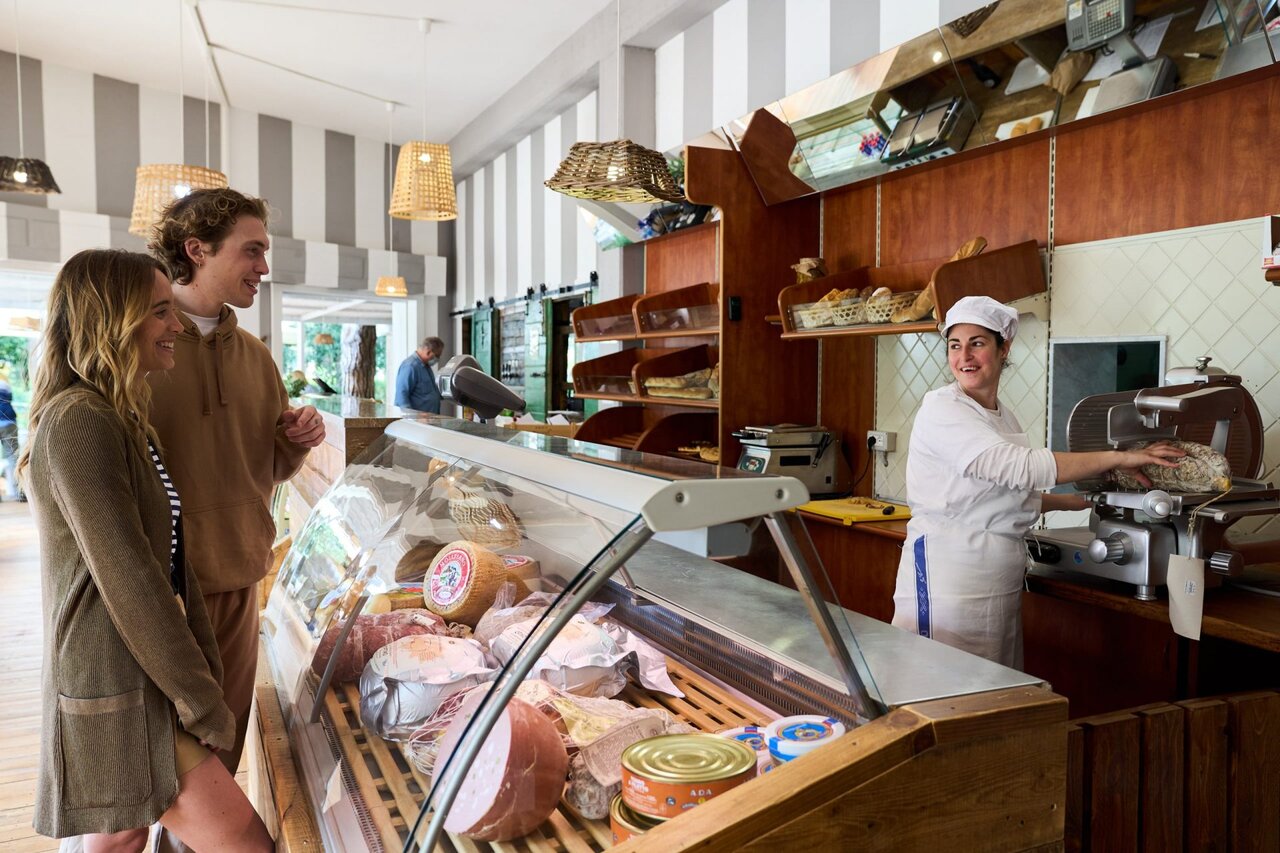 Tienda de comestibles del camping con embutidos y quesos en CAPFUN Campo dei Fiori en Rosignano Marittimo (57).