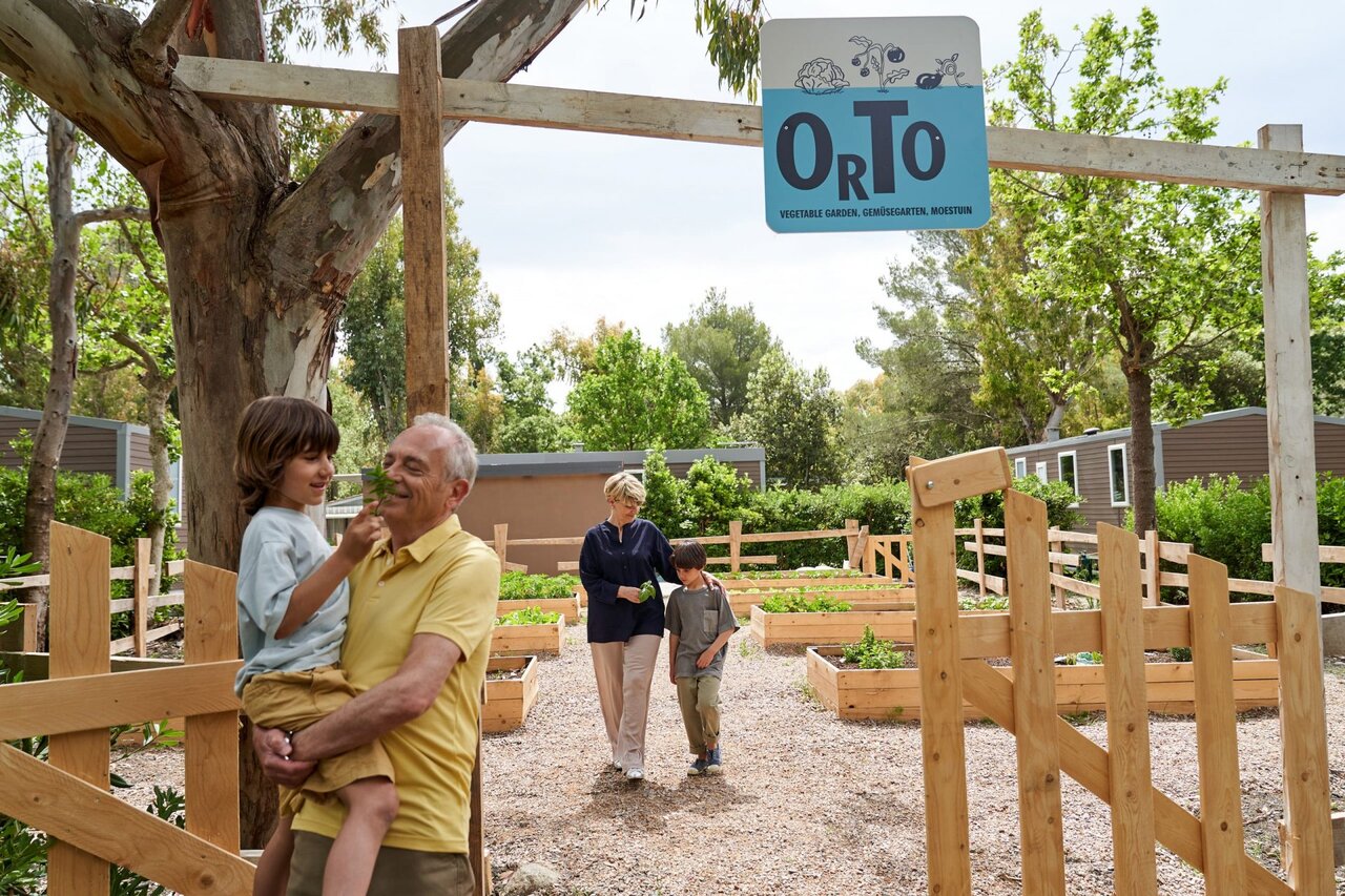 Familia disfrutando del huerto en el camping CAPFUN Campo dei Fiori en Rosignano Marittimo (57).
