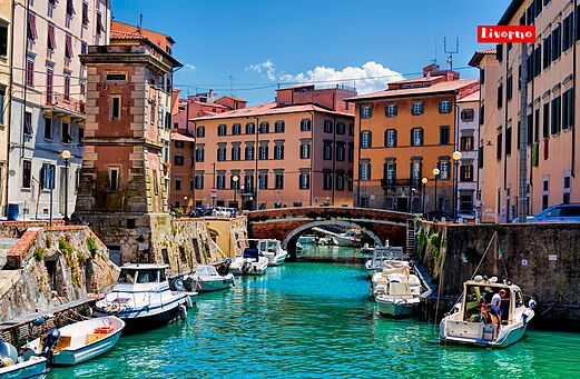 Canales pintorescos de Livorno con barcos y edificios coloridos en Toscana.