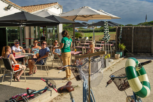 Terraza exterior del restaurante con clientes en el camping CLICOCHIC Camp du Soleil.